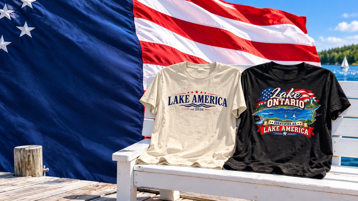 Cream Lake America and black Lake Ontario Identifies As Lake America T-shirts displayed beside a lake